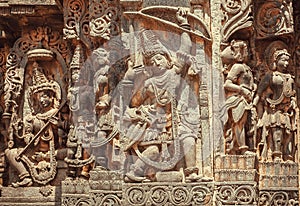South Indian temple relief with hero Arjuna with bow and arrows in hands. Hindu structure 12th century, Halebidu, India