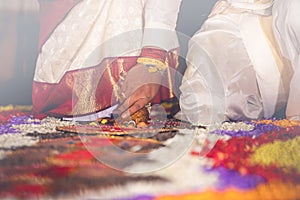 South Indian wedding ritual Saptapadi. Groom holding brides foot during marriage