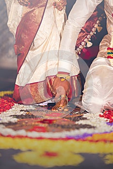 South Indian wedding ritual Saptapadi. Groom holding brides foot during marriage