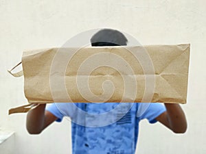 South Indian young man giving shopping bag.