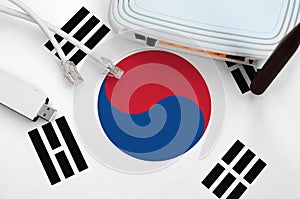 South Korea flag depicted on table with internet rj45 cable, wireless usb wifi adapter and router. Internet connection concept