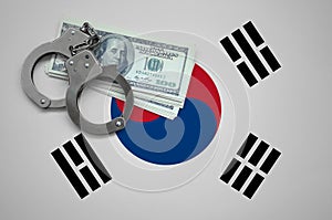 South Korea flag with handcuffs and a bundle of dollars. The concept of breaking the law and thieves crimes