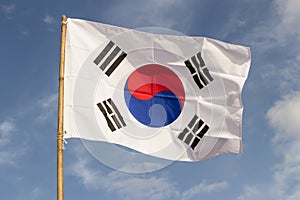 South Korea flag waving against cloudy blue sky