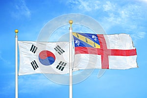 South Korea and Herm two flags on flagpoles and blue cloudy sky