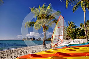 South Pacific island scene with colorful kayaks on the beach.