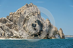 South view on El Arco behind tall booulder, Cabo San Lucas, Mexico photo