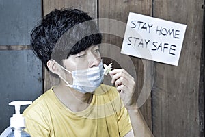 Southeast Asian, Chinese and Myanmar young man with cold flu gets loss of smell called anosmia photo