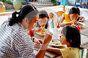 Southeast Asian Family Spending Quality Time Together Having Healthy Lunch at a Restaurant