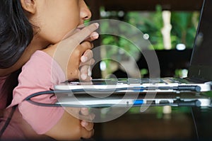 Southeast Asian teenage schoolgirl in front of a laptop. Closeup portrait