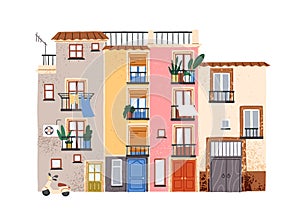 Southern apartment building facade. Old colorful South house exterior with plants and laundry on balconies. Cozy Spanish