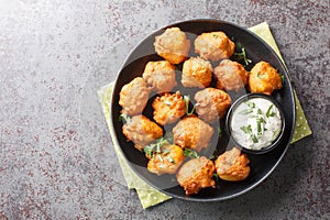 Southern Hush Puppies are light and flakey cornmeal dough that is fried golden brown on the outside and soft on the inside closeup