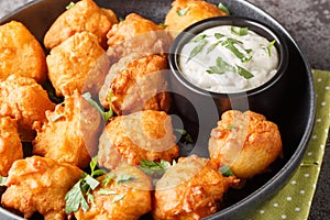 Southern Hush Puppies are light and flakey cornmeal dough that is fried golden brown on the outside and soft on the inside closeup