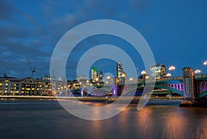 Southwark Bridge from the south bank of the River Thames in the early evening