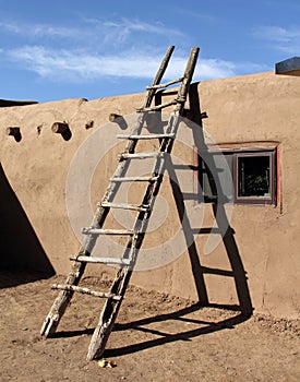 Southwestern ladder leaning against adobe wall in Taos Pueblo