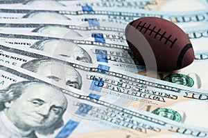 Souvenir ball for playing rugby or American football on US banknotes. The concept of corruption or sports betting. photo