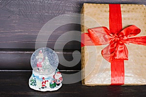 Souvenir glass Christmas snow globe and gift wrapped in Kraft paper