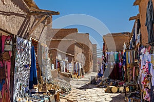 Souvenir shop with carpets, traditional clothes and other things in clay town of Ait Ben Haddou, Morocco.