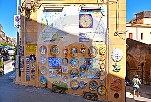 27.08.2018. Souvenir shop with typical ceramic products of Sicilian style showing on wall outside building on the street in the ol