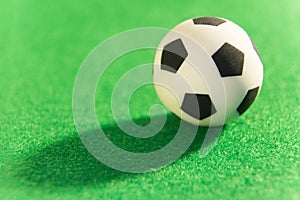 Souvenir soccer ball on a green background. A symbol of football. Macro. Super close-up.