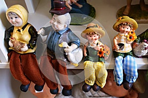 Souvenir toys and vintage resin grandfather old man doll and retro grandmother senior woman and children grandchild on shelf for