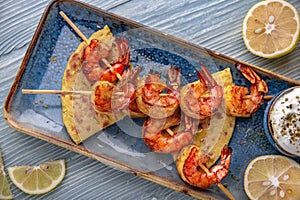 Souvlaki grilled shrimp on skewers. Natural delicious food. Greek cuisine menu. Still life in a marine style.