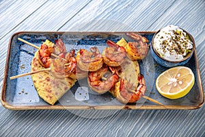 Souvlaki grilled shrimp on skewers. Natural delicious food. Greek cuisine menu. Still life in a marine style.