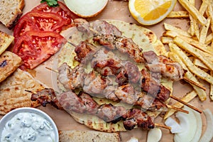 Souvlaki, meat skewers, traditional greek turkish meat food on pita bread, tzatziki sauce and potatoes