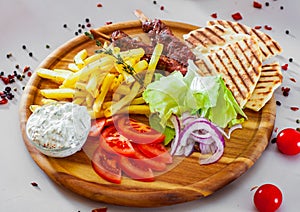 Souvlaki with salad, french fries potato, pita and tzatziki sauce