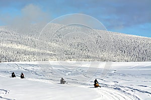 SOVATA, ROMANIA - Jan 18, 2019: landscape with people on snowmobile on a winter field