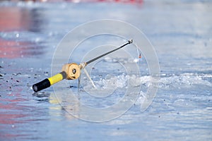 Soviet fishing rod for winter fishing stands on the ice near the ice hole