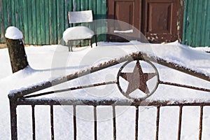 Soviet five finger star on a fence door background an old wooden fence