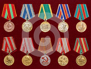 Soviet military medals and awards for valiant labor on red background photo