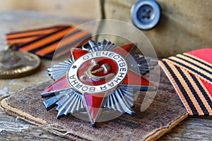 Soviet Order of the Patriotic War inscription Patriotic War and fighting medals on an old wooden table. May 9 victory day in the