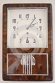 Soviet wall brown simple clock with pendulum is on photo