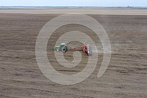 Sowing of corn. Tractor with a seeder on the field