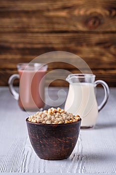 Soy beans and cup of cacao and small creamer on wooden table