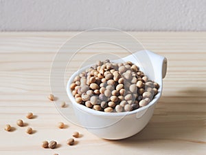 Soy beans in white bowl on wooden table
