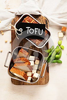 Soy food. Baked tofu cheese on a board, soybeans. Vegan product