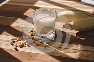 Soy milk, bananas and soy beans on a wooden table