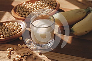 Soy milk, bananas and soy beans on a wooden table