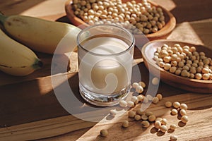 Soy milk, bananas and soy beans on a wooden table