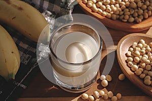 Soy milk, bananas and soy beans on a wooden table