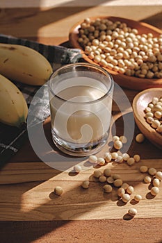 Soy milk, bananas and soy beans on a wooden table