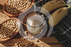 Soy milk, bananas and soy beans on a wooden table