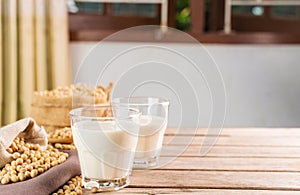 Soy milk in a glass with soybeans on a wooden table organic drink high protein healthy breakfast agricultural produce vegetarian