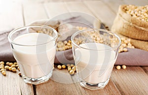 Soy milk in a glass with soybeans on a wooden table organic drink high protein healthy breakfast agricultural produce vegetarian