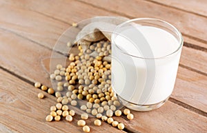 Soy milk in a glass with soybeans on a wooden table organic drink high protein healthy breakfast agricultural produce vegetarian