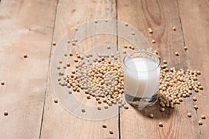 Soy milk or soya milk and soy beans in spoon on wooden table.