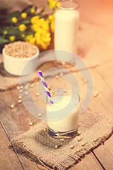 Soy milk or soya milk and soy beans on wooden table.