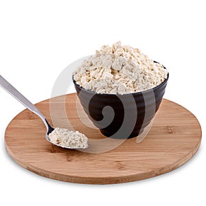 Soy powder in brown bowl and spoon on wood board isolated on white background, copy space.